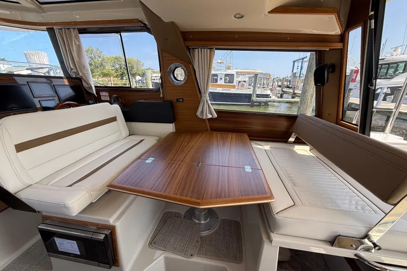 Slide: The Image of Interior of 2026 Ranger Tugs R-29 CB with elegant seating and wooden table. - 12