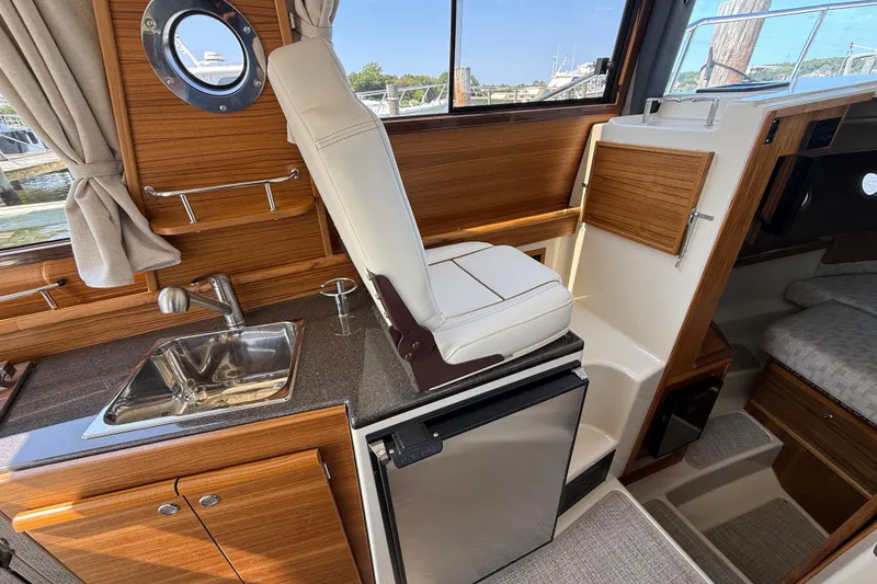 Slide: The Image of Interior of 2026 Ranger Tugs R-29 CB with sink, fridge, and seating. - 15