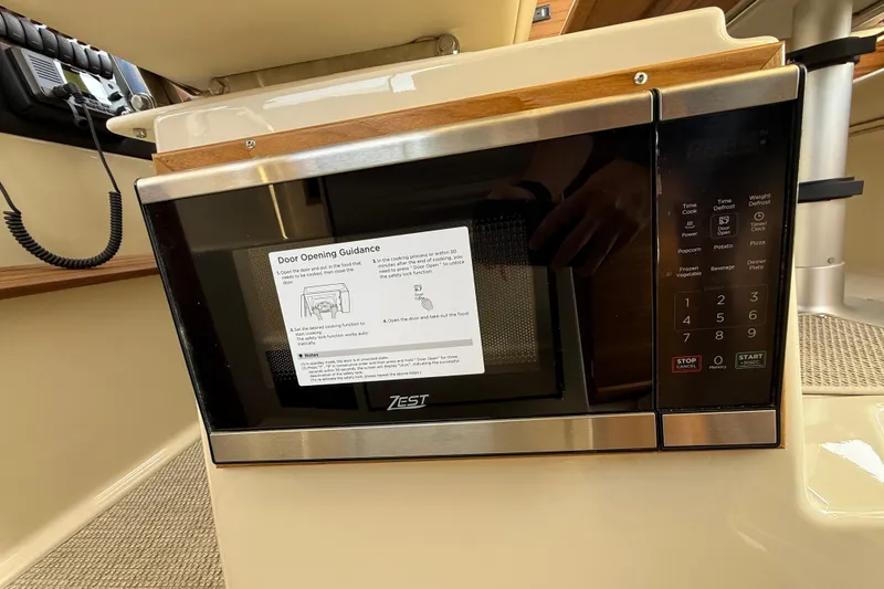 Slide: The Image of Microwave inside 2026 Ranger Tugs R-29 CB boat, featuring control panel and door opening guidance. - 17