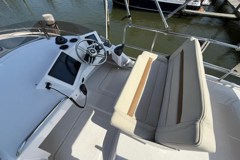 Slide: The Image of 2026 Ranger Tugs R-29 CB helm with steering wheel, touchscreen, and cushioned seating. - 6