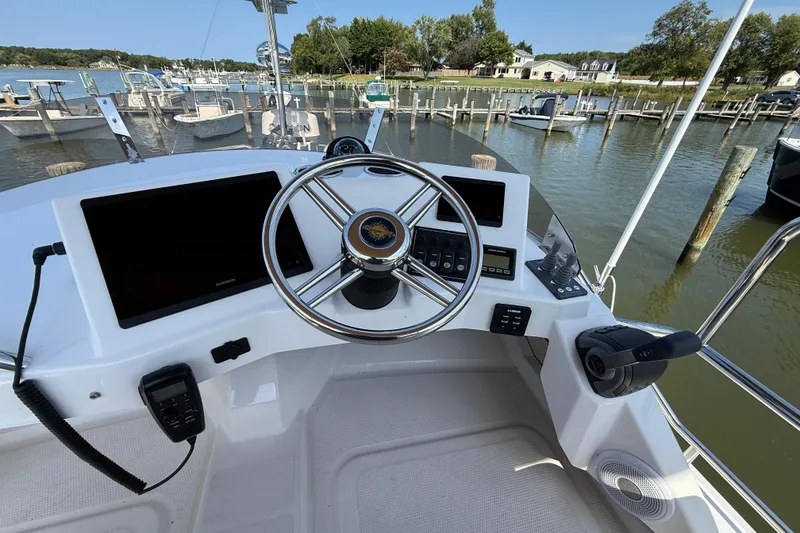 Slide: The Image of 2026 Ranger Tugs R-29 CB helm with modern controls and dual displays at marina. - 7
