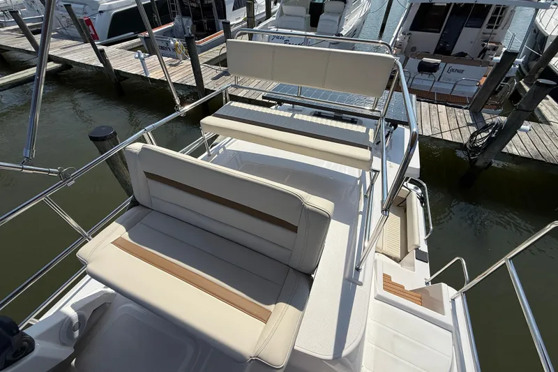 Slide: The Image of 2026 Ranger Tugs R-29 CB boat with cushioned seating, docked at marina. - 8