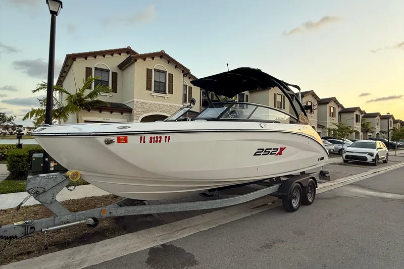 Slide: The Image of 2022 Yamaha Boats 252XE on trailer by the sea, under a clear blue sky. - 2
