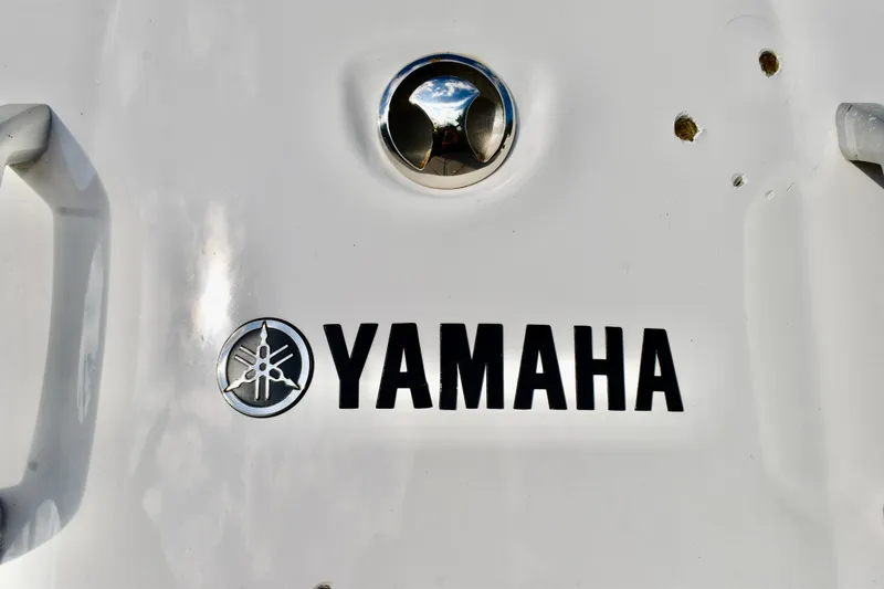 Slide: The Image of 2022 Yamaha Boats 252XE interior with modern dashboard and seating, overlooking a scenic waterfront. - 21