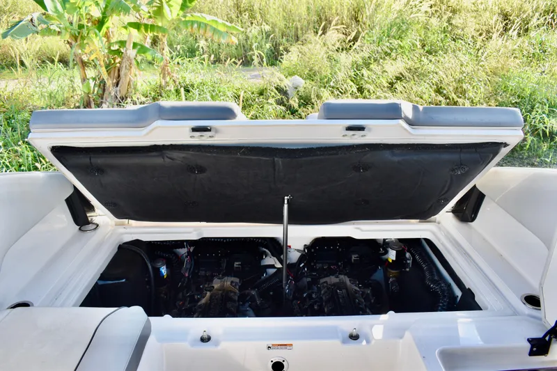 Slide: The Image of 2022 Yamaha Boats 252XE engine compartment open, showcasing dual engines in a lush outdoor setting. - 32