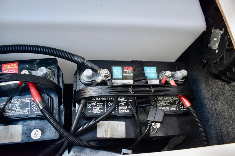 Slide: The Image of 2022 Yamaha Boats 252XE battery compartment with dual marine batteries. - 33