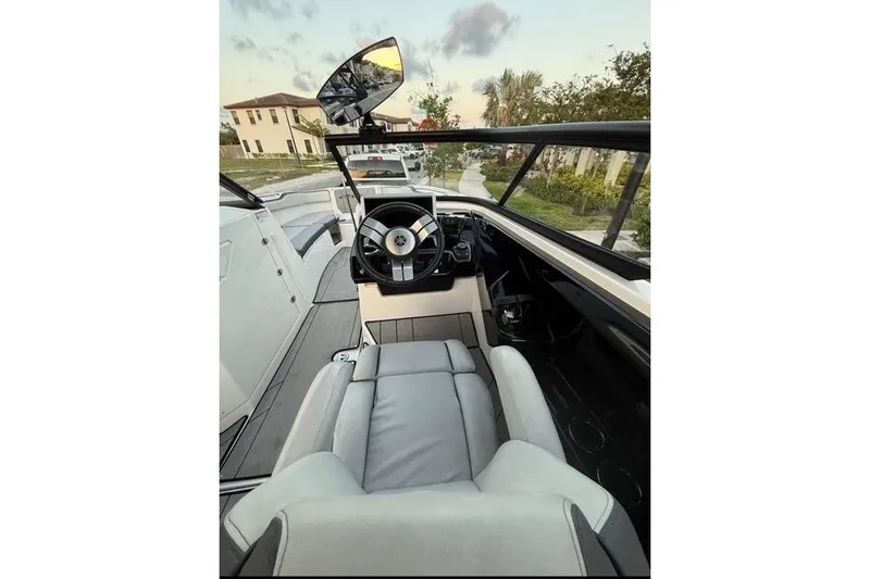 Slide: The Image of 2022 Yamaha Boats 252XE with sleek seating and speaker, under a blue sky. - 7
