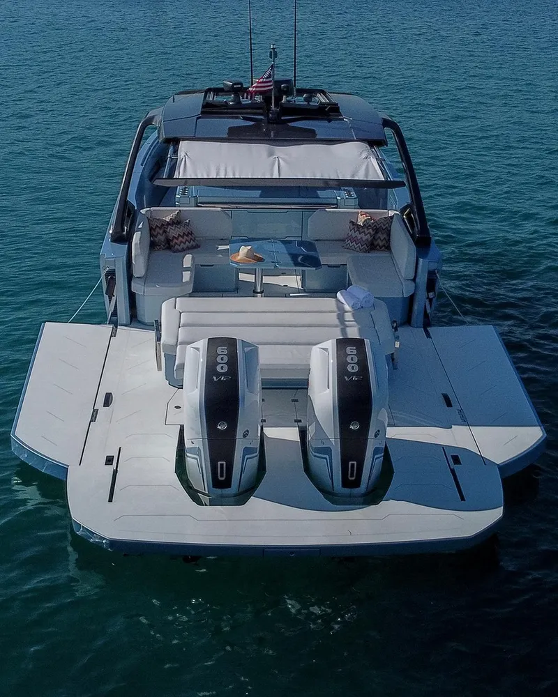 Slide: The Image of 2023 Limitless Seas XLV luxury yacht with twin outboard engines on serene water. - 14