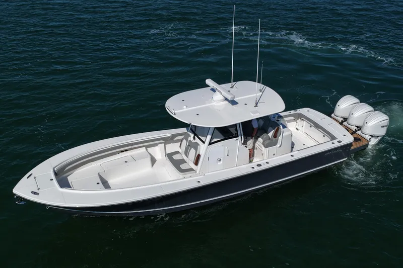 Slide: The Image of 2024 Regulator 34 boat cruising on open water, featuring triple outboard engines. - 16