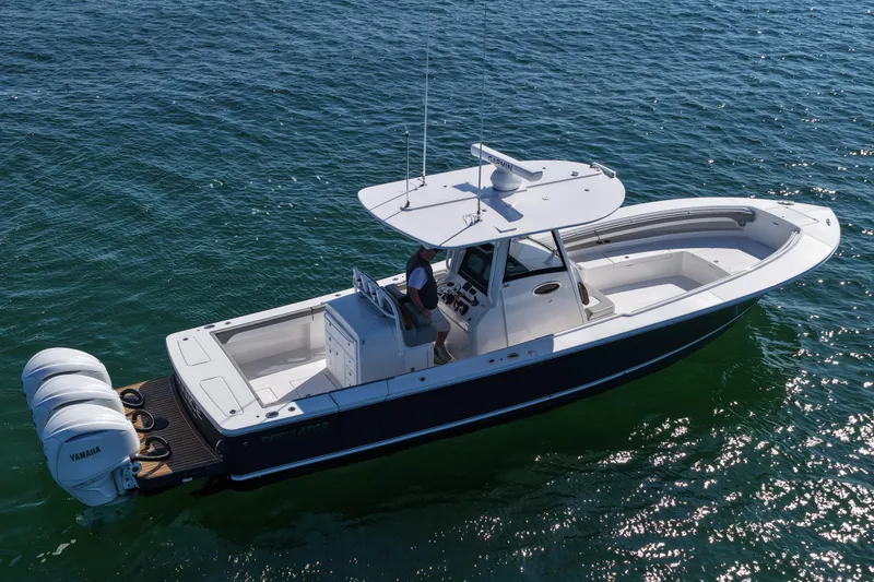 Slide: The Image of 2024 Regulator 34 boat on open water, featuring triple Yamaha engines. - 20