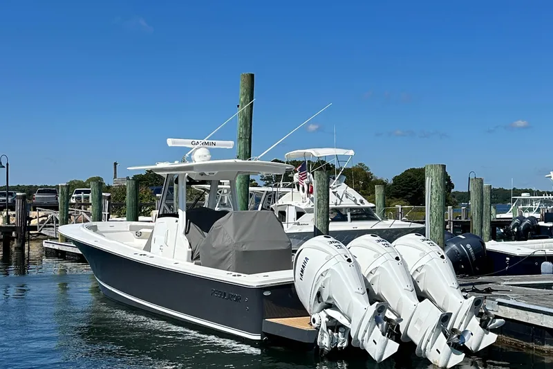 Slide: The Image of 2024 Regulator 34 boat docked with triple Yamaha engines, clear blue sky background. - 22