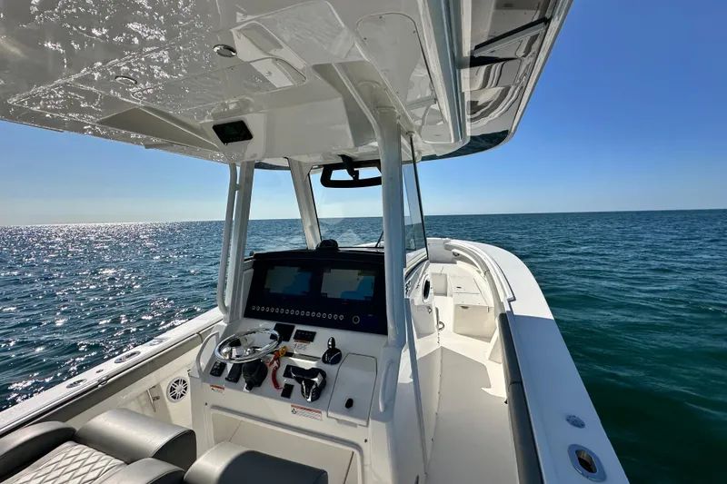Slide: The Image of 2024 Regulator 34 boat on open sea, featuring modern helm and clear blue skies. - 23