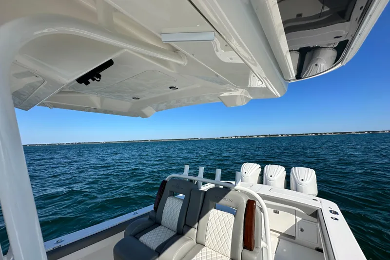Slide: The Image of 2024 Regulator 34 boat interior with ocean view, featuring luxurious seating and multiple engines. - 25