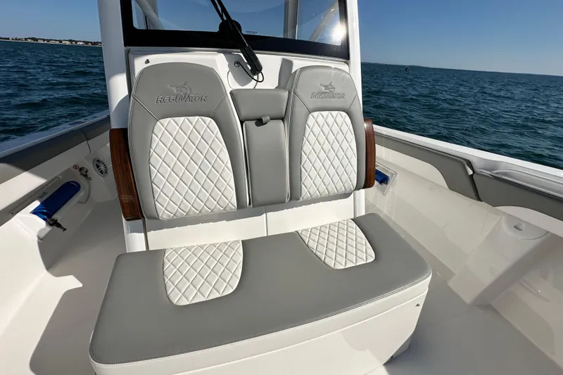 Slide: The Image of 2024 Regulator 34 boat with luxurious seating, diamond-stitched upholstery, and ocean backdrop. - 36