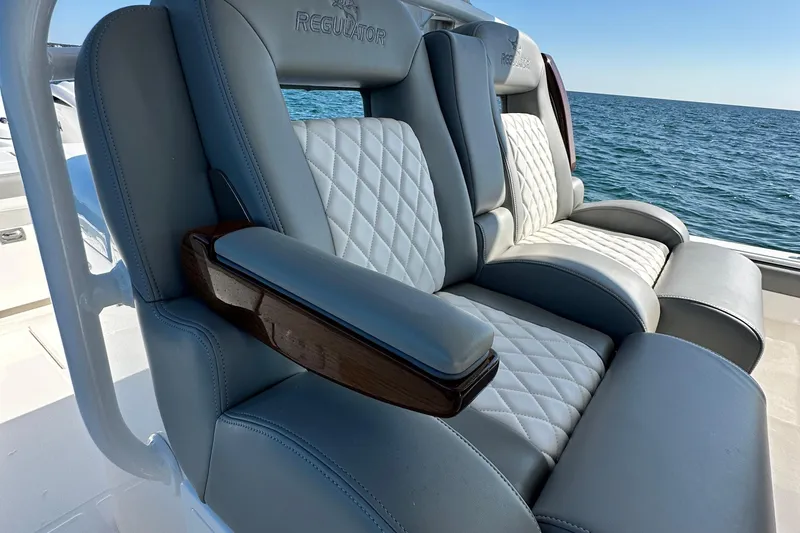 Slide: The Image of Luxurious seating on 2024 Regulator 34 boat with quilted upholstery, ocean backdrop. - 37