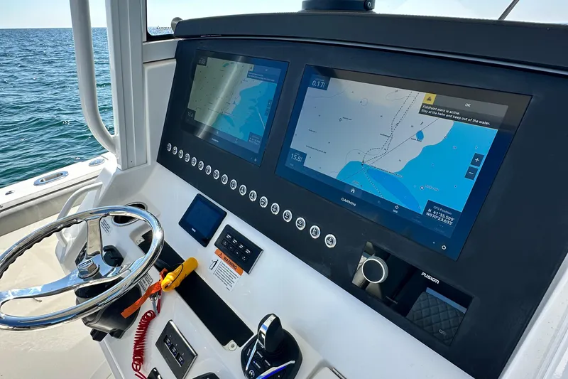 Slide: The Image of 2024 Regulator 34 boat dashboard with navigation screens and steering wheel. - 40