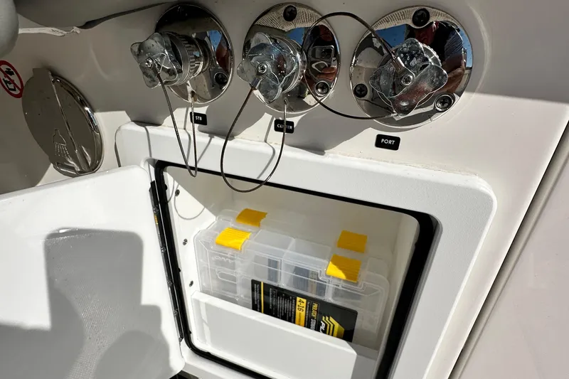 Slide: The Image of 2024 Regulator 34 boat storage compartment with tackle box and chrome fittings. - 42