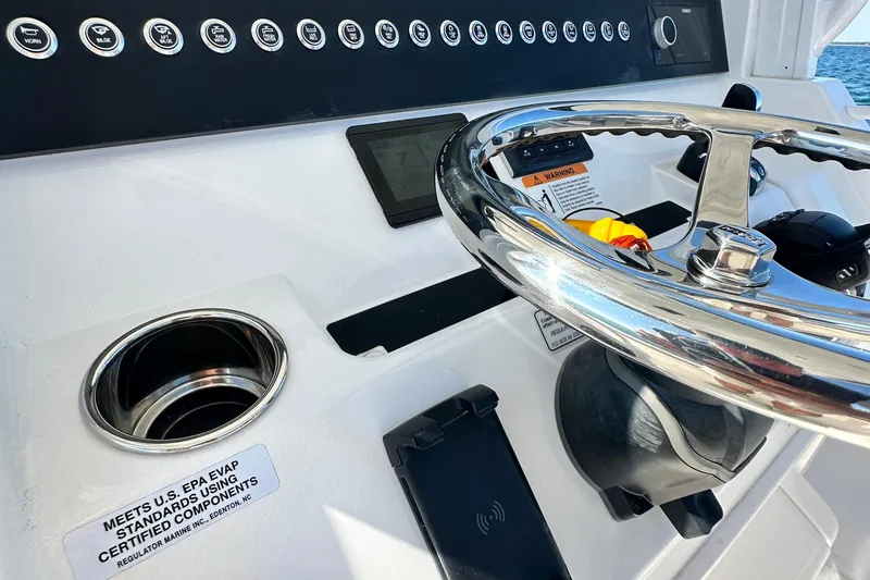 Slide: The Image of 2024 Regulator 34 boat helm with steering wheel and control panel. - 44