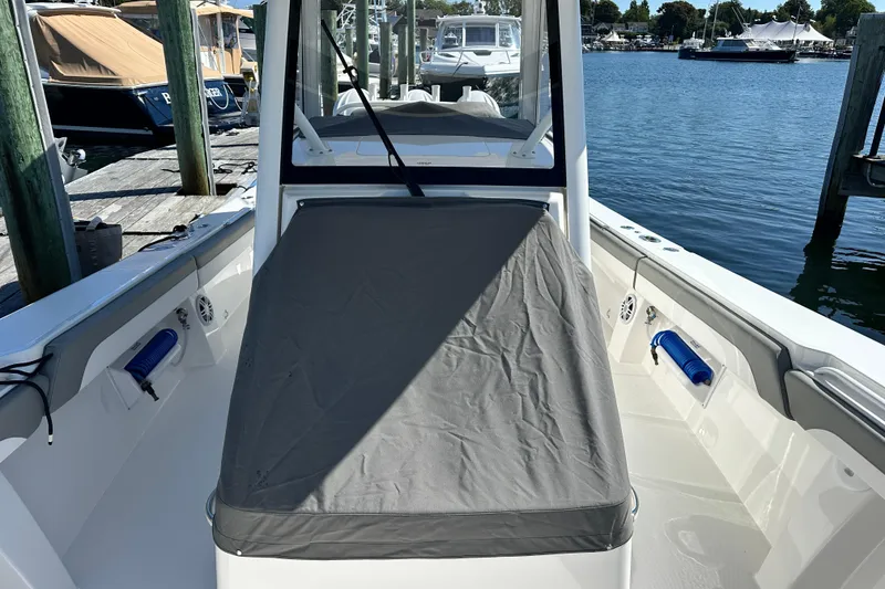 Slide: The Image of 2024 Regulator 34 boat docked, featuring a covered seating area and sleek design. - 46