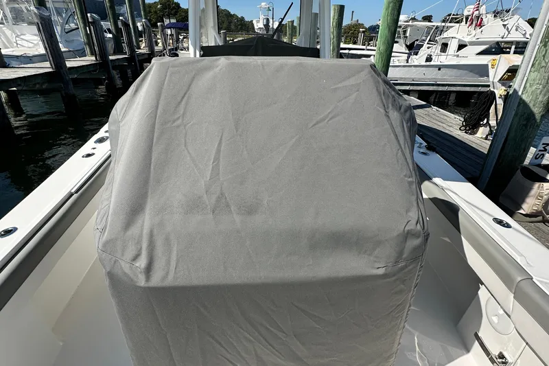 Slide: The Image of 2024 Regulator 34 boat console covered with a protective gray cover at a marina. - 47