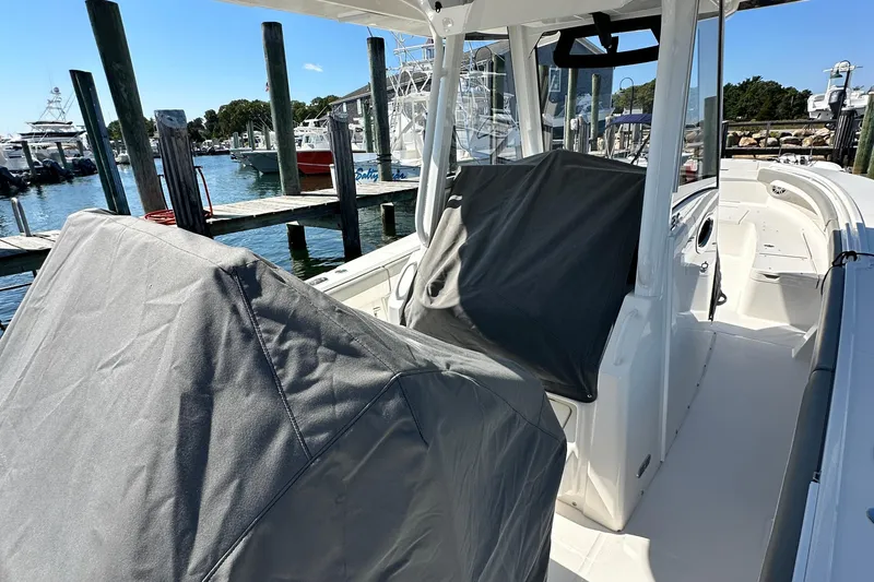 Slide: The Image of 2024 Regulator 34 boat interior at marina, covered seats, sunny day. - 48