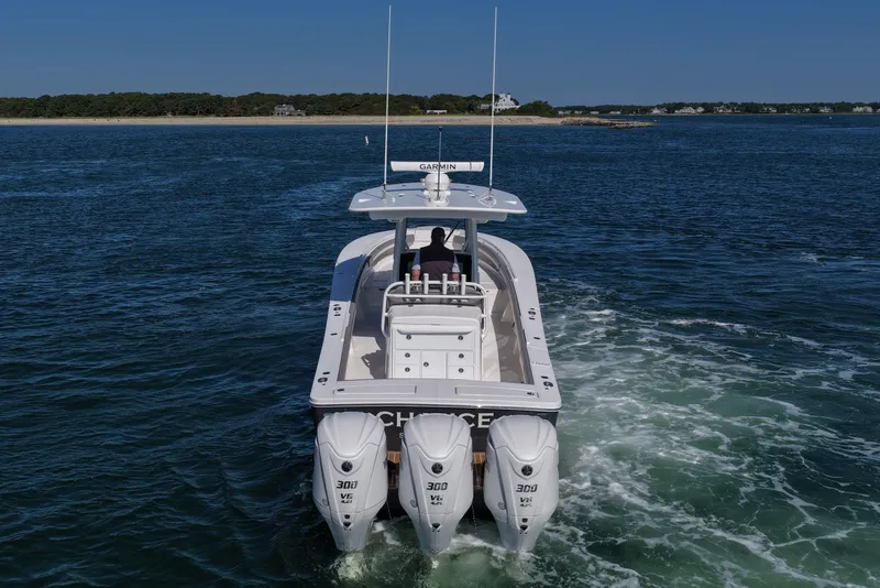 Slide: The Image of 2024 Regulator 34 boat cruising on open water with triple 300 horsepower engines. - 6