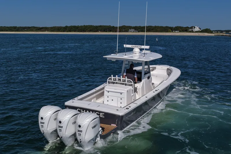 Slide: The Image of 2024 Regulator 34 boat with triple Yamaha engines cruising on open water. - 7