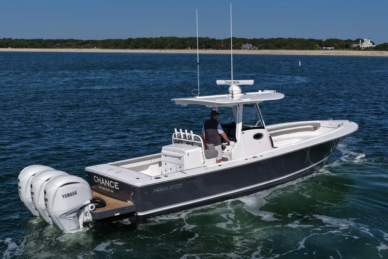 Slide: The Image of 2024 Regulator 34 boat cruising on open water with triple Yamaha engines. - 8
