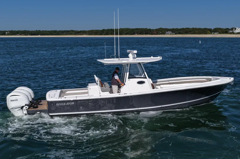 Slide: The Image of 2024 Regulator 34 boat cruising on open water with Yamaha engines. - 9