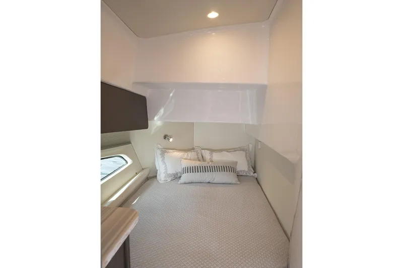 Slide: The Image of Cozy cabin interior of 2022 Intrepid 477 Evolution yacht with bed and window. - 19