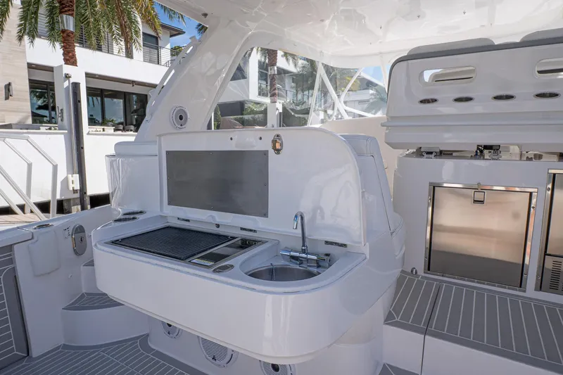 Slide: The Image of 2022 Intrepid 477 Evolution yacht interior with modern kitchenette and sleek design. - 8