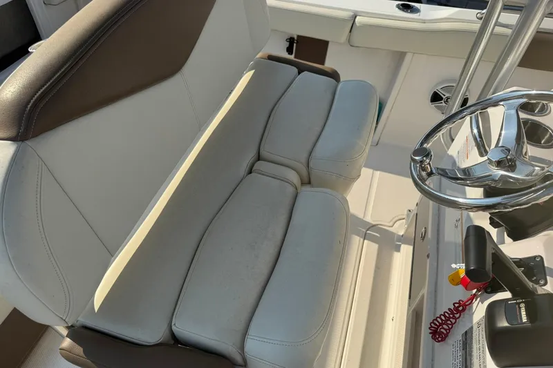 Slide: The Image of 2017 Robalo R222ES boat interior with steering wheel and cushioned seating. - 10