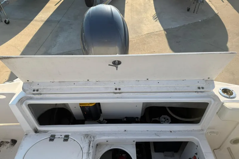 Slide: The Image of 2017 Robalo R222ES boat storage compartment with open hatch, revealing interior components. - 18