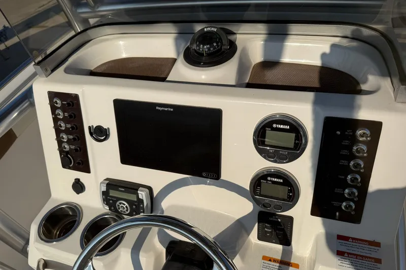Slide: The Image of 2017 Robalo R222ES boat dashboard with Yamaha gauges and Raymarine display. - 2