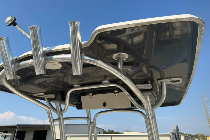 Slide: The Image of 2017 Robalo R222ES boat T-top with rod holders against blue sky. - 27