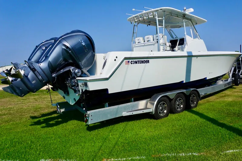 Slide: The Image of 2022 Contender 39 Fisharound boat cruising on open water, featuring triple outboard engines. - 8