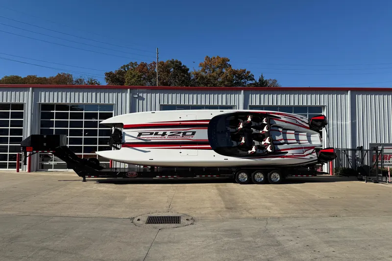 The Image of 2025 Performance Powerboats P420 on trailer outside industrial building. - 0