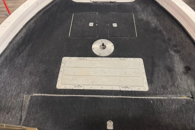 Slide: The Image of 1993 Yar-Craft 1890 CRS boat deck with storage compartments and black carpeting. - 15