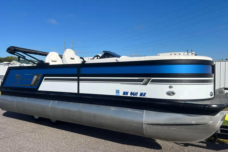 The Image of 2022 Viaggio Diamante Q pontoon boat with blue and white design, parked outdoors. - 0