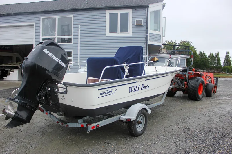 Slide: The Image of 2007 Boston Whaler 170 Montauk boat on trailer with Mercury engine, parked near a building. - 1