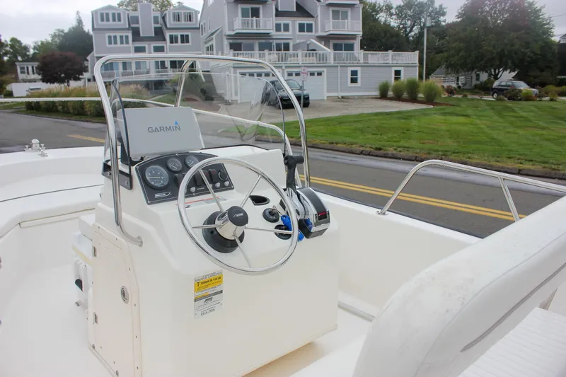 Slide: The Image of 2007 Boston Whaler 170 Montauk boat with Garmin navigation, parked near residential area. - 12