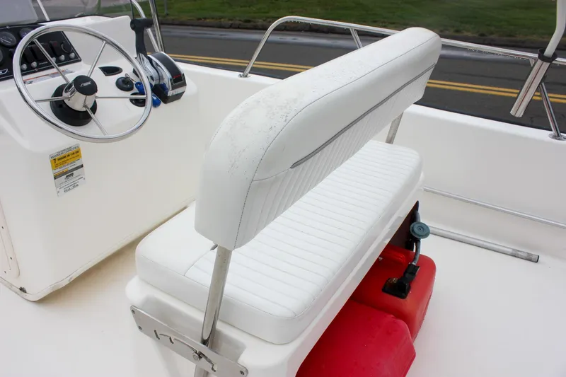 Slide: The Image of 2007 Boston Whaler 170 Montauk boat interior with steering wheel and white seating. - 13
