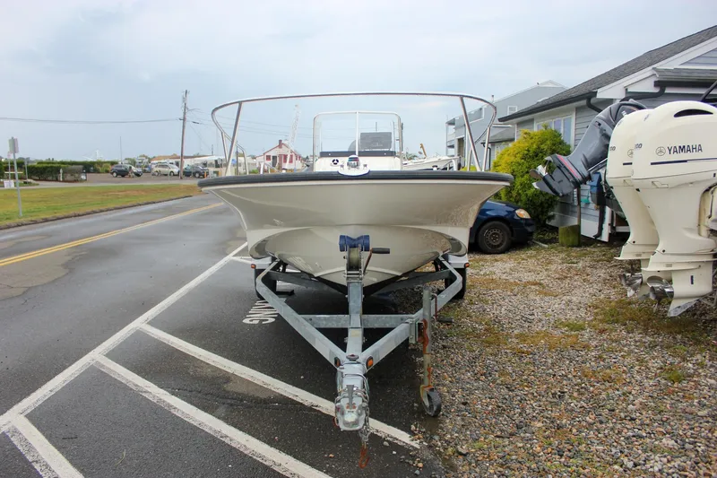 Slide: The Image of 2007 Boston Whaler 170 Montauk boat on trailer, parked near road and buildings. - 20