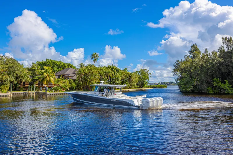 Slide: The Image of 2019 HCB 53 Sueños boat cruising on a scenic river under a clear blue sky. - 2