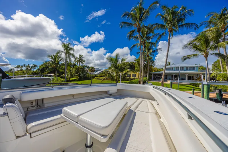 Slide: The Image of 2019 HCB 53 Sueños boat with luxurious seating, docked near palm trees and waterfront homes. - 22
