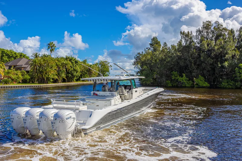 Slide: The Image of 2019 HCB 53 Sueños boat cruising on a scenic waterway with lush greenery. - 5