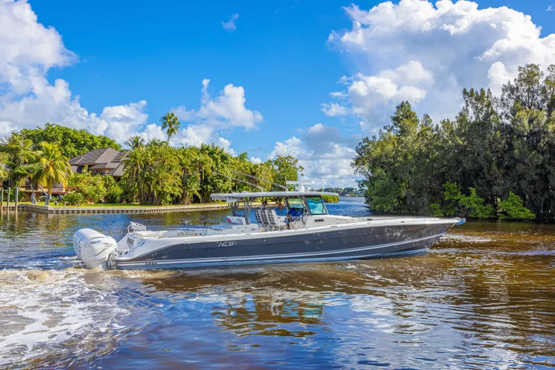 Slide: The Image of 2019 HCB 53 Sueños boat cruising on a scenic river with lush greenery. - 7