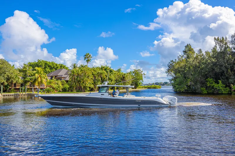 Slide: The Image of 2019 HCB 53 Sueños boat cruising on a scenic river under a bright blue sky. - 1