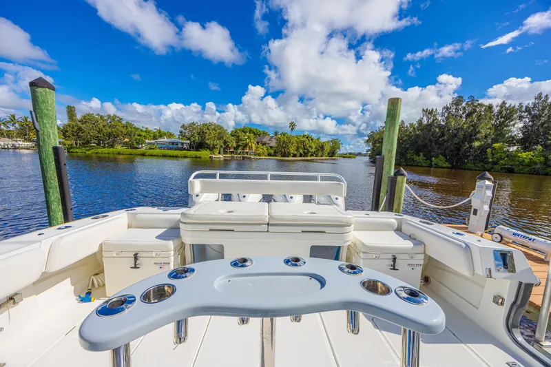 Slide: The Image of 2019 HCB 53 Sueños boat docked on a scenic river under a vibrant blue sky. - 11