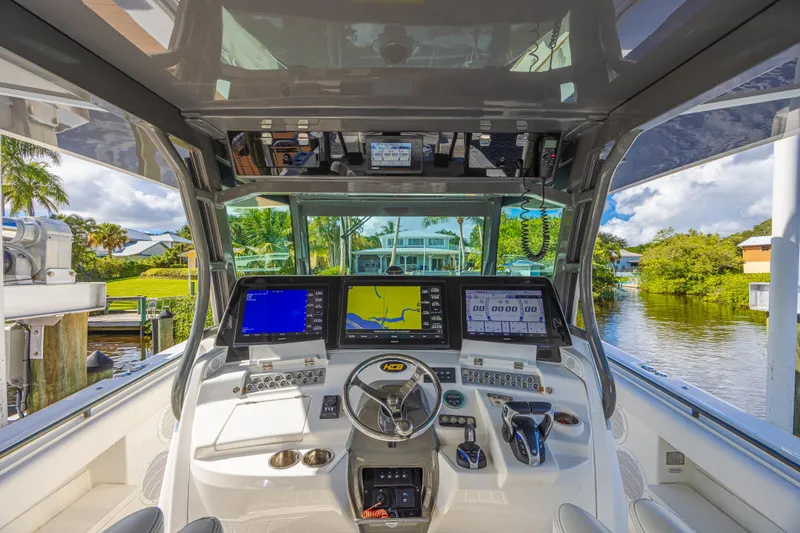 Slide: The Image of Cockpit of 2019 HCB 53 Sueños boat with advanced navigation systems and scenic waterway view. - 21